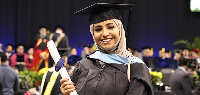 Pitt graduate holding diploma