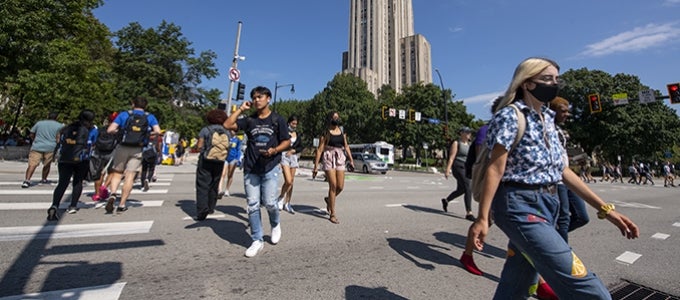 students crossing at Bigelow Boulevard and Forbes Avenue with Cathedral of Learning in background