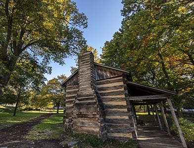 log cabin on campus lawn