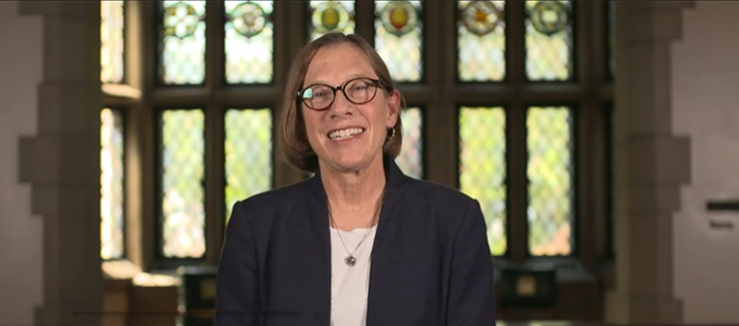 provost in front of leaded glass windows