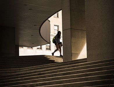 student walking on steps into Pitt Law building