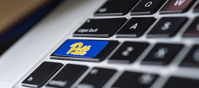 closeup of laptop keyboard with Pitt logo sticker on Shift key