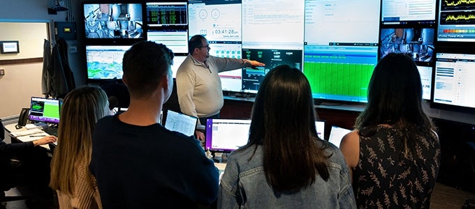 lots of computer screens on view during student tour of UPMC Data Center