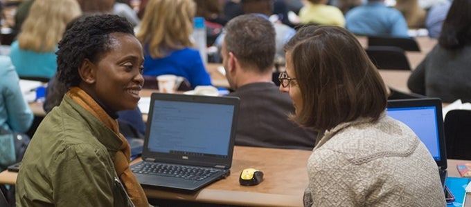 attendees talking at faculty symposium