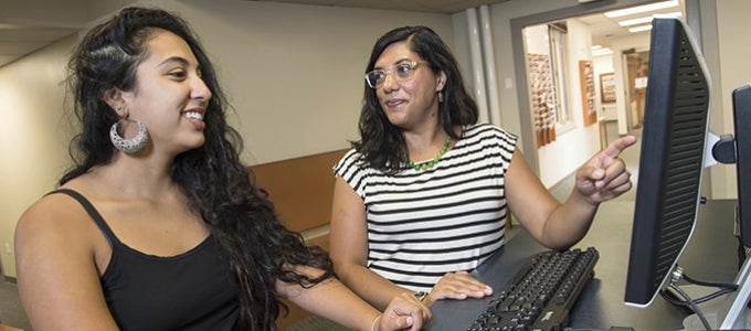 student and advisory look at computer screen together during a meeting.