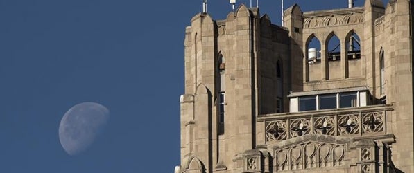 top of Cathedral of Learning with moon showing beside it