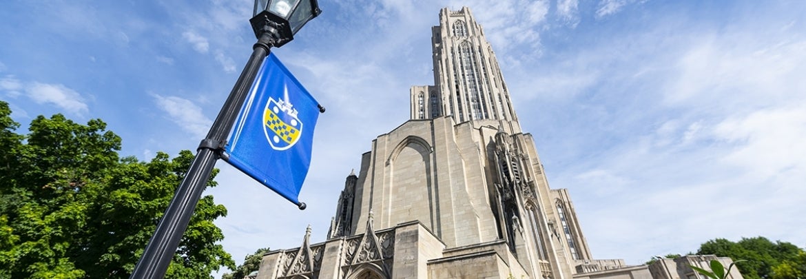 Pitt banner on lamp post with Cathedral of Learning in background