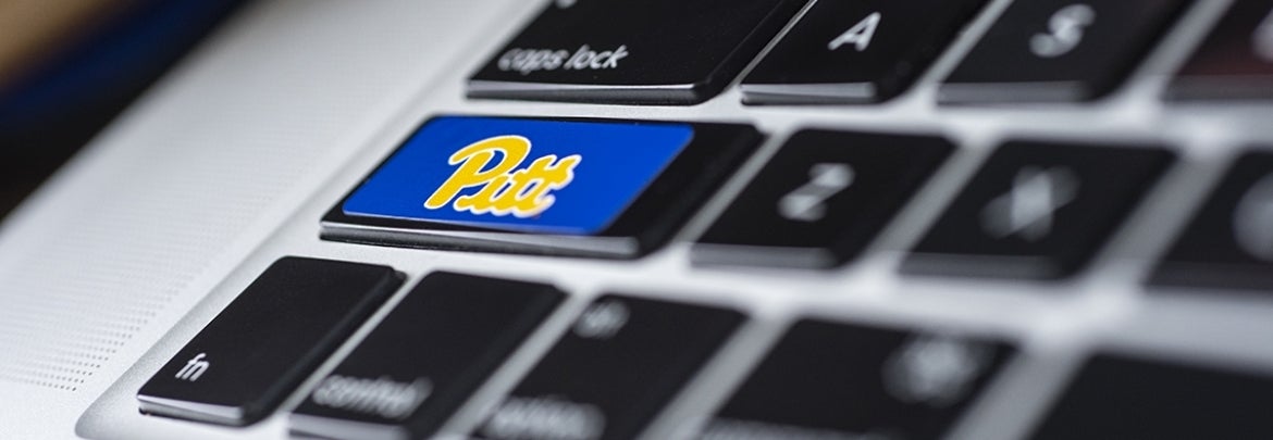 closeup of laptop keyboard with Pitt logo sticker on shift key