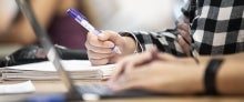 closeup of Pitt students taking notes in class